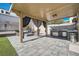 Covered patio with outdoor kitchen, fire pit, and seating at 5599 Valley Mill St, Las Vegas, NV 89148