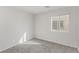 Bright bedroom featuring neutral walls, plush carpeting, and a window for natural light at 6382 Lonesome Lake St, Las Vegas, NV 89148