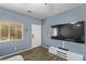 Living room with large TV, entryway, and wood-look floors at 6382 Lonesome Lake St, Las Vegas, NV 89148