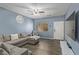 Living room featuring sectional sofa, ceiling fan and wood-look floors at 6382 Lonesome Lake St, Las Vegas, NV 89148