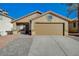 Single story home with tan exterior, paved driveway, and attached garage at 6560 Bush Clover Ln, Las Vegas, NV 89156