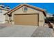 Tan house with a two-car garage and brick paver driveway at 6560 Bush Clover Ln, Las Vegas, NV 89156