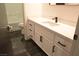 Simple bathroom with white vanity and dark floor tiles at 7409 Flat Rock St, Las Vegas, NV 89131