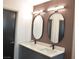 Double vanity bathroom with modern dark gray cabinets and oval mirrors at 7409 Flat Rock St, Las Vegas, NV 89131