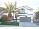 Two-story house with gray garage door and palm trees at 7409 Flat Rock St, Las Vegas, NV 89131