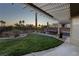 Sunset view of backyard oasis with pergola, grass, and patio furniture at 750 Arguello Cir, Mesquite, NV 89027