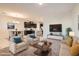 Staged living room with comfortable seating, contemporary decor, and seamless connection to the kitchen and dining area at 762 Star Estates Ave, North Las Vegas, NV 89086