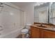 Clean bathroom featuring a bathtub, toilet, and vanity with brown wood cabinets at 8284 Arden Ladder Pl, Las Vegas, NV 89117