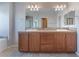 Double vanity bathroom with wood cabinets and a large mirror at 8284 Arden Ladder Pl, Las Vegas, NV 89117