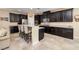 Modern kitchen with dark cabinetry, granite counters, and island at 844 Via Serenelia, Henderson, NV 89011