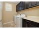 Laundry room with washer, dryer, and dark wood cabinets at 844 Via Serenelia, Henderson, NV 89011