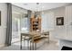 Bright dining area with farmhouse table, bench and sliding glass door leading to the backyard at 889 Ariel Heights Ave, Las Vegas, NV 89138