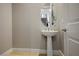 Small powder room with pedestal sink and oval mirror at 9008 Rolling Pietra St, Las Vegas, NV 89166