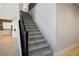 Modern staircase with gray carpeting and a sleek black railing at 9008 Rolling Pietra St, Las Vegas, NV 89166