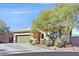 Single-story house with green garage door and landscaped yard at 10330 Glacier Mist Ave, Las Vegas, NV 89149