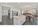 Bright and modern kitchen with white cabinetry, granite countertops, and stainless steel appliances, open to the dining and living areas at 10330 Glacier Mist Ave, Las Vegas, NV 89149