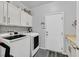 Modern laundry room with white cabinetry, countertop space, a laundry sink and modern washer and dryer at 10330 Glacier Mist Ave, Las Vegas, NV 89149