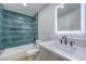 Spa-like bathroom with teal tile, updated vanity, and a bathtub at 133 Dogwood St, Henderson, NV 89015