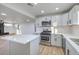 Open concept kitchen with island, white cabinets, and stainless steel appliances at 133 Dogwood St, Henderson, NV 89015