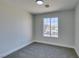 Bright bedroom with grey carpet and large window at 1850 Banaba Ln, Las Vegas, NV 89156