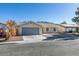 Single story home with gray garage door and landscaping at 1850 Banaba Ln, Las Vegas, NV 89156