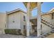 Exterior view of the building featuring stucco walls, red tile roof, and metal stairs to the front door at 1963 Scimitar Dr # 0, Henderson, NV 89014