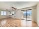 Bright living room featuring wood floors, ceiling fan, and a sliding glass door to the outdoor balcony at 1963 Scimitar Dr # 0, Henderson, NV 89014