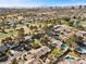 Aerial view showcasing a neighborhood with houses, pools, and lush green spaces at 2192 Geronimo Way, Las Vegas, NV 89169