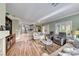 Bright and airy living room with hardwood floors and a view into the kitchen at 2373 Rosendale Village Ave, Henderson, NV 89052