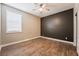 Bedroom with dark accent wall, wood-look floors, and ceiling fan at 2905 Carothers Ct, North Las Vegas, NV 89032