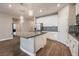 Modern kitchen with white cabinets, granite island, and mosaic backsplash at 2905 Carothers Ct, North Las Vegas, NV 89032