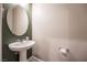 Clean powder room with pedestal sink and oval mirror at 2905 Carothers Ct, North Las Vegas, NV 89032