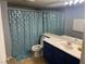 Bathroom with blue vanity, shower, and patterned curtain at 2962 Juniper Hills Blvd # 203, Las Vegas, NV 89142