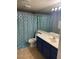 Bathroom with blue vanity, shower, and patterned curtain at 2962 Juniper Hills Blvd # 203, Las Vegas, NV 89142