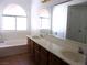 Bathroom with double sinks, large mirror, and a bathtub at 3139 Ocotillo Dr, Laughlin, NV 89029