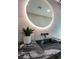 Modern bathroom features a floating vanity with black marble countertop and a large round mirror at 3180 S Tioga Way, Las Vegas, NV 89117