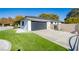 Modern home exterior with a black garage door and artificial turf at 3180 S Tioga Way, Las Vegas, NV 89117