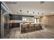 Modern kitchen with dark cabinetry, island, and marble countertops at 3180 S Tioga Way, Las Vegas, NV 89117