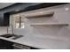 Kitchen features floating shelves and marble backsplash at 3180 S Tioga Way, Las Vegas, NV 89117