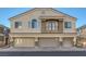 Three-car garage townhome with a small balcony and a neutral stucco finish at 3309 Jamaica Princess Pl # 3, North Las Vegas, NV 89084