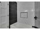 Clean bathroom with black and white tile and a new bathtub at 3367 Vema Dr, Las Vegas, NV 89121