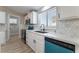 Modern kitchen with white cabinets, teal dishwasher, and quartz countertops at 3446 Cactus Springs Dr, Las Vegas, NV 89115