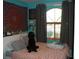 Bedroom with a queen bed, dark-colored dog, and teal walls at 3925 Vulcan St, Las Vegas, NV 89122