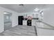 Modern kitchen with white cabinets, black appliances, and gray flooring at 402 Bell Ave, Henderson, NV 89015