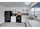 Modern kitchen with white cabinets, black appliances, and gray flooring at 402 Bell Ave, Henderson, NV 89015