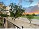 Landscaped backyard overlooking a golf course with sunset view at 5381 Waving Sage Dr, Las Vegas, NV 89149