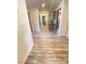 Well-lit hallway with wood-style flooring, blue cabinets, and access to various rooms at 5381 Waving Sage Dr, Las Vegas, NV 89149