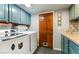 Laundry room with teal cabinets and wood flooring at 5381 Waving Sage Dr, Las Vegas, NV 89149