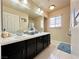 Elegant bathroom with double sinks, dark brown vanity, and a large mirror at 6454 Mount Palomar Ave, Las Vegas, NV 89139