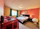 Colorful bedroom with orange and yellow walls, featuring a comfortable bed at 6454 Mount Palomar Ave, Las Vegas, NV 89139